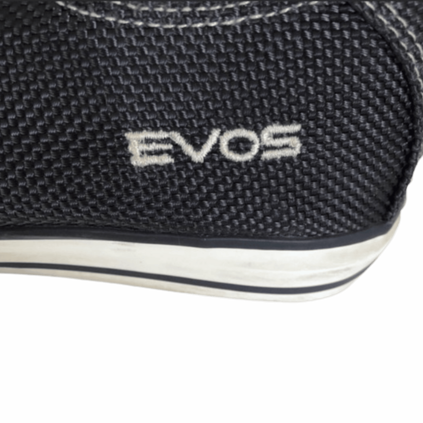 Close-up of a black shoe with 'EVOS' branding on a white background