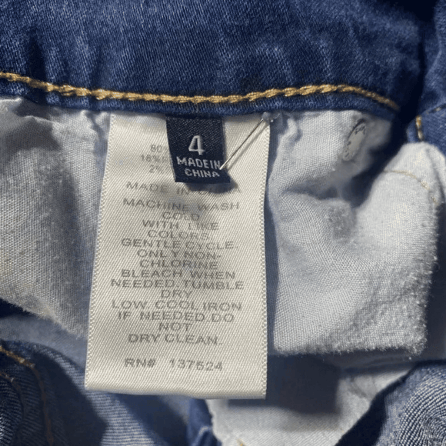 Clothing tag on a denim garment with washing instructions.