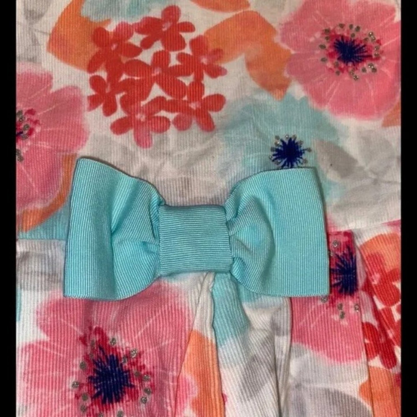 Turquoise bow on a floral fabric background