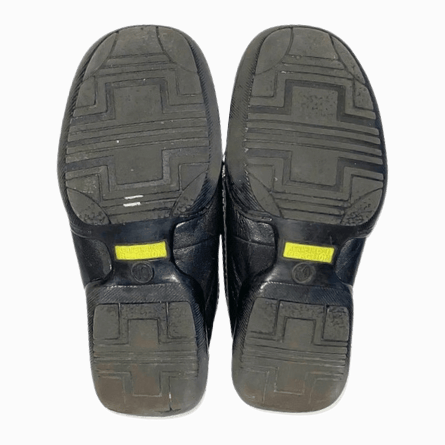 Black shoes with textured soles on a gray background