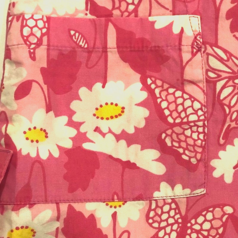 Close-up of a pink floral patterned fabric with flowers and leaves.