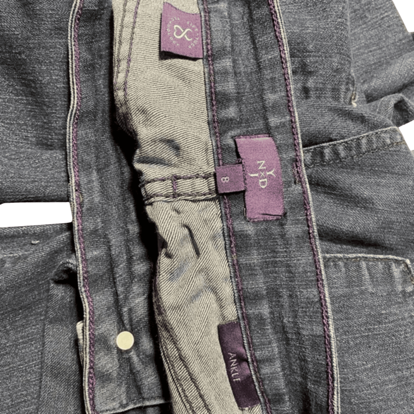 Close-up of a gray jacket with purple labels on a green background