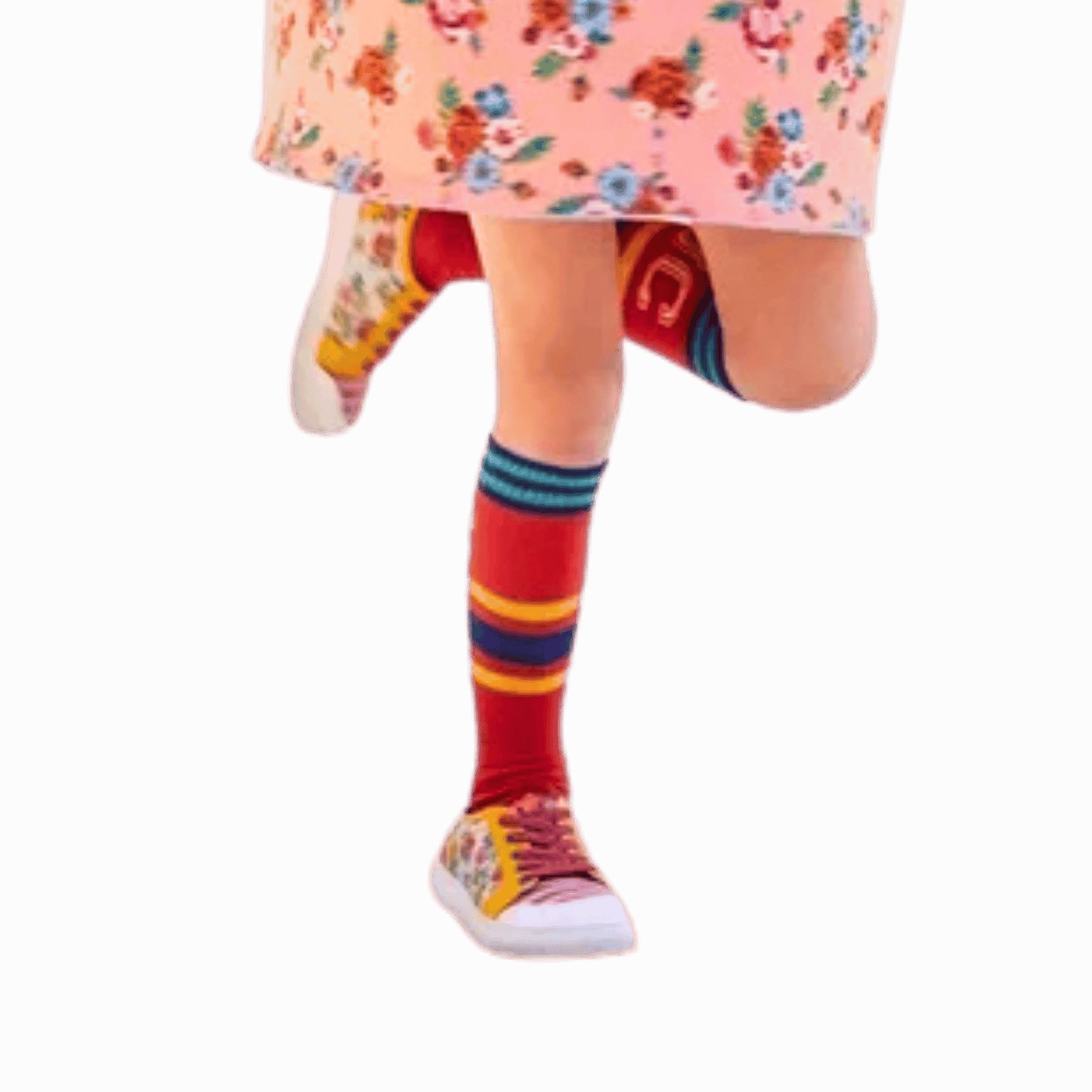 Colorful striped socks worn with a floral dress and sneakers on a red background
