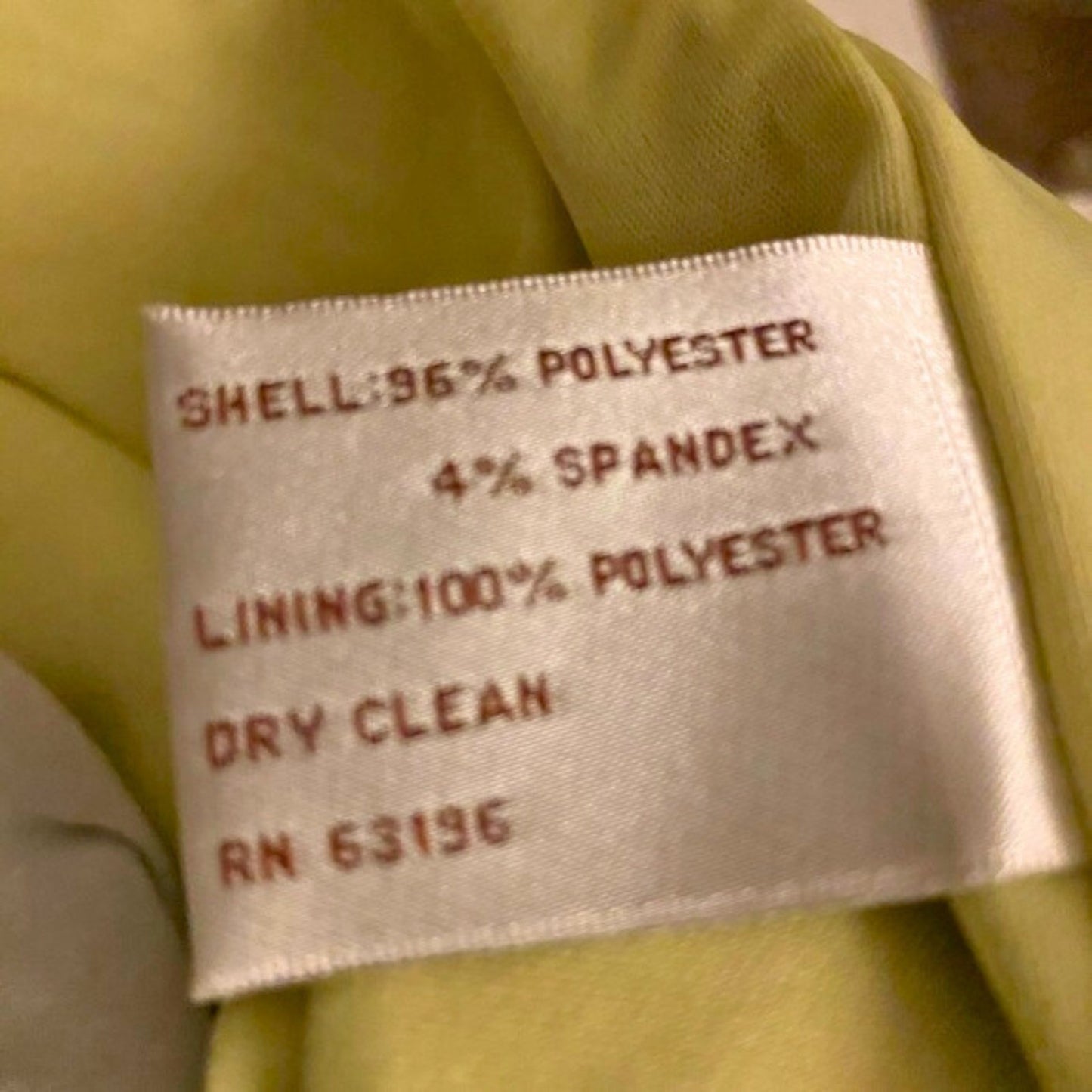 Fabric label with material information on a green fabric background