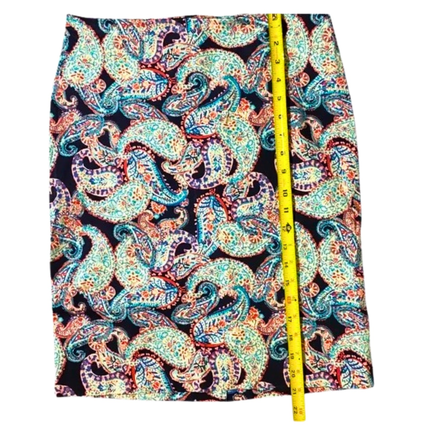 Colorful paisley patterned fabric with a measuring tape on a white background
