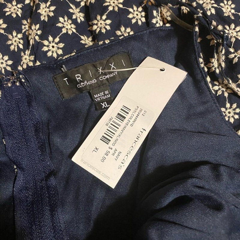 Navy blue garment with a TRIXI label on a floral background