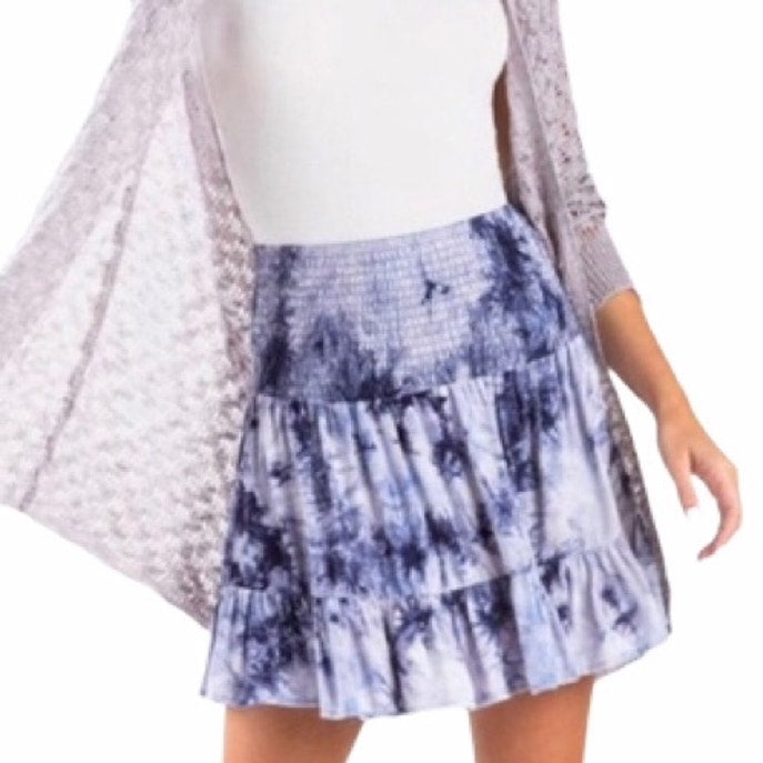 Person wearing a tie-dye skirt with a white background