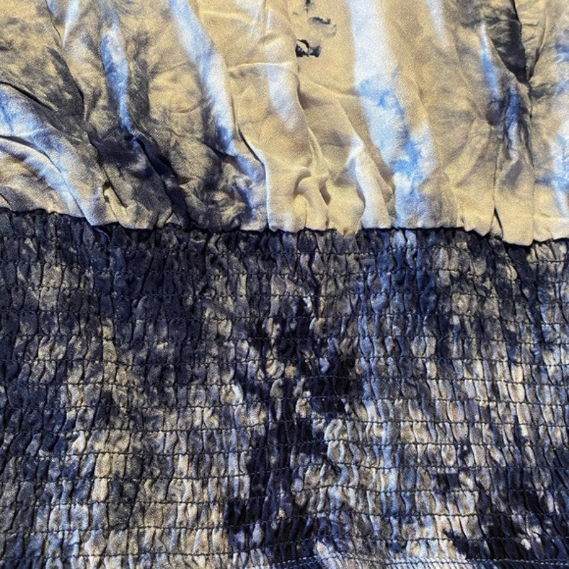 Close-up of a tie-dye patterned fabric with blue and beige colors.