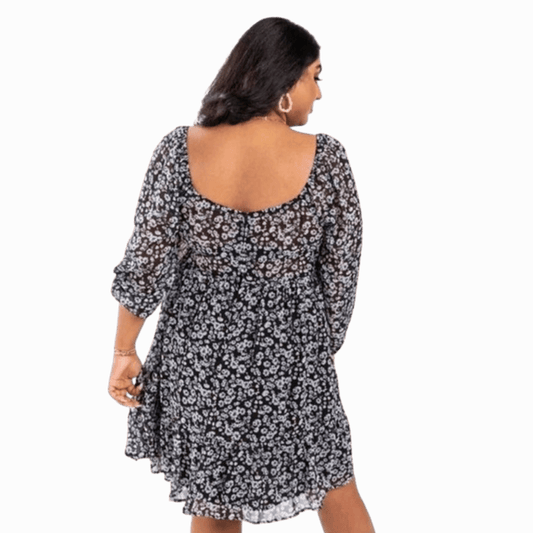 Woman wearing a black floral dress on a gray background