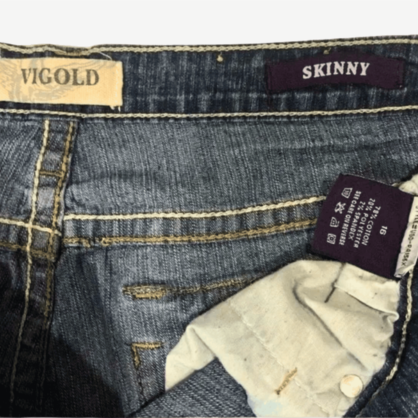 Close-up of blue jeans with brand labels on the waistband and hem.