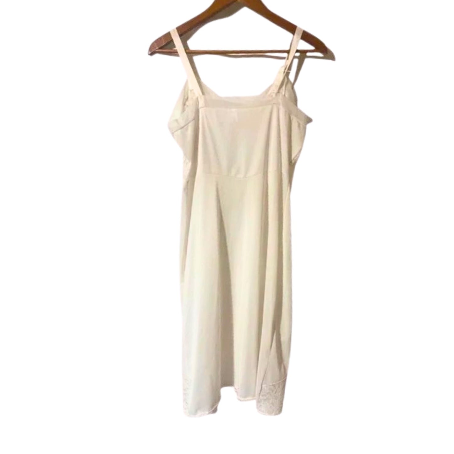 Beige slip dress on a wooden hanger against a white background
