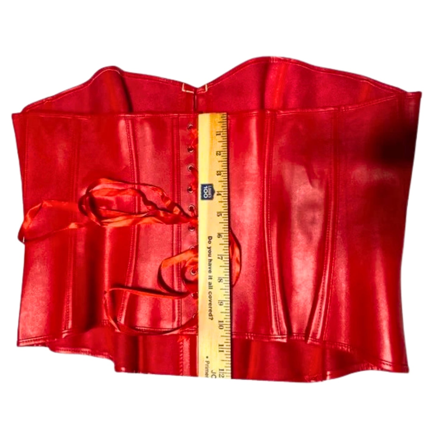 Red leather corset with a ruler for scale on a white background