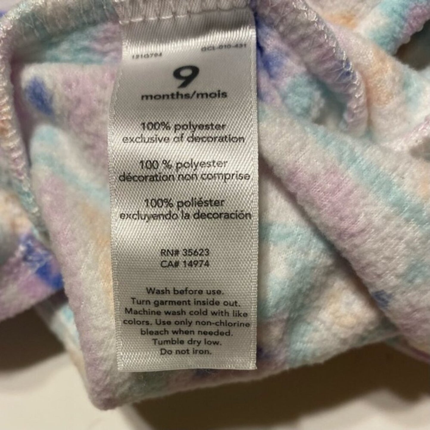 Fabric tag with washing instructions on a multicolored fabric background