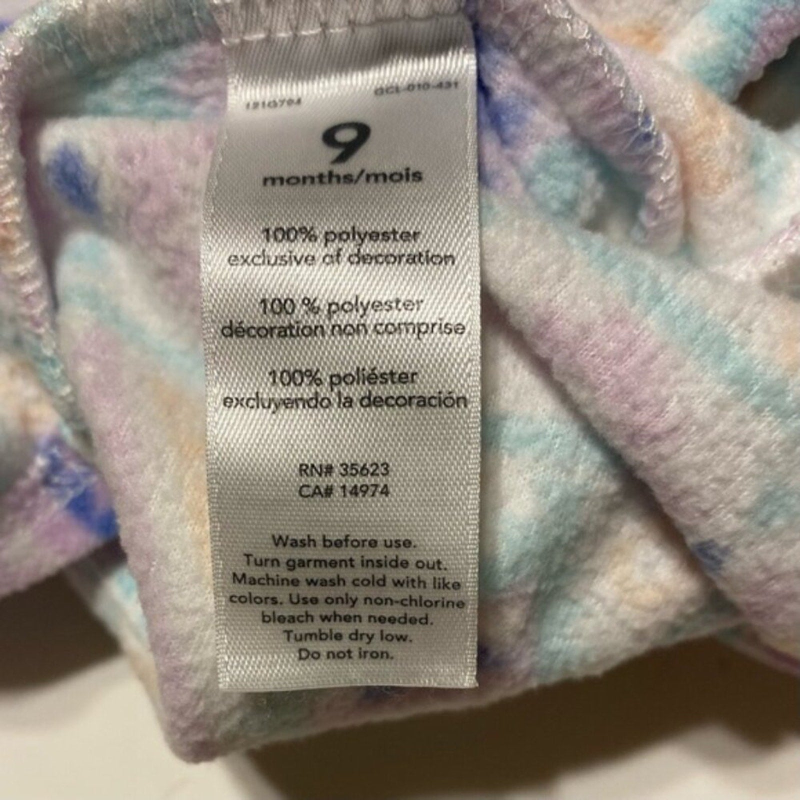 Fabric tag with washing instructions on a multicolored fabric background