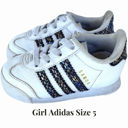 White sneakers with decorative stripes and 'Samo' branding on a beige background