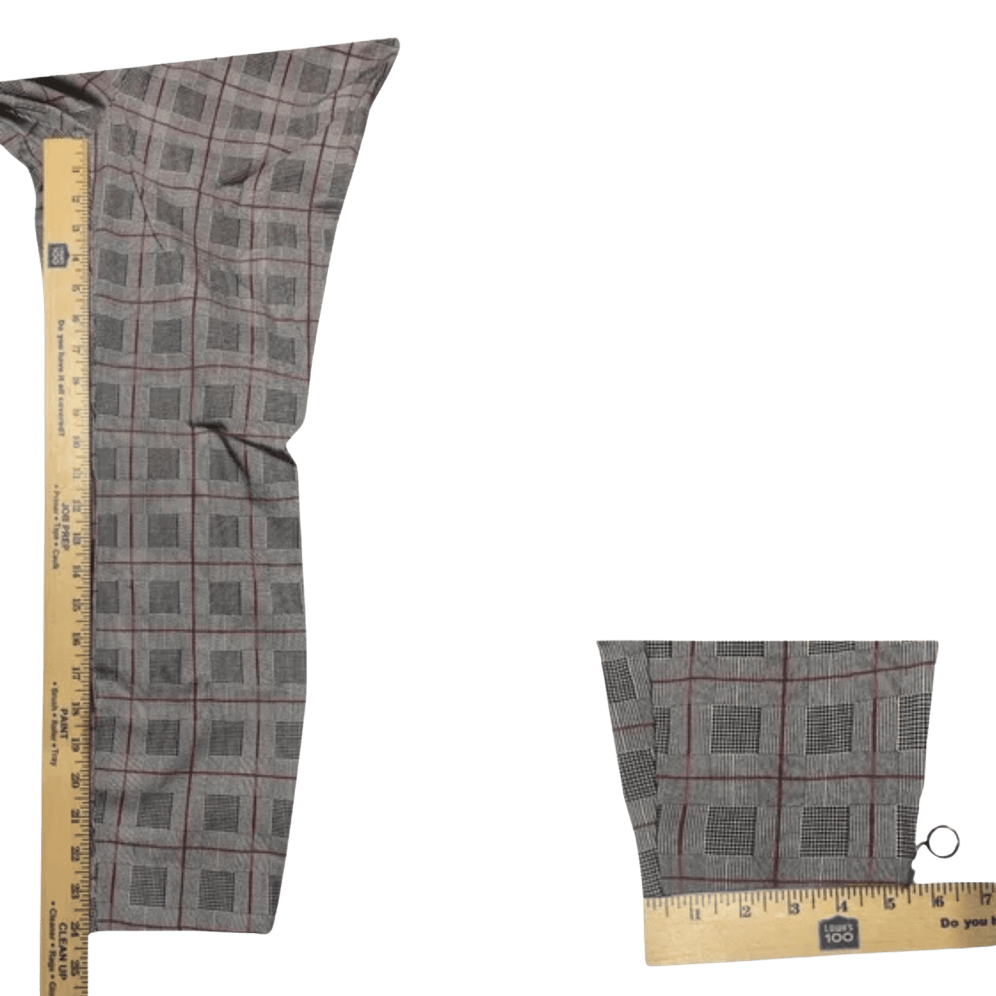 Plaid fabric swatch with a ruler for scale on a green background