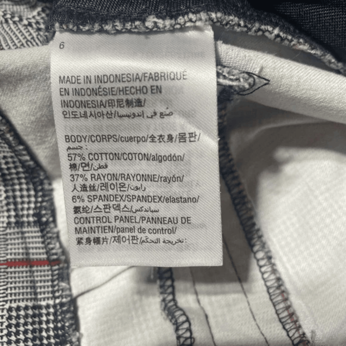 Fabrication label on a garment with text in multiple languages.