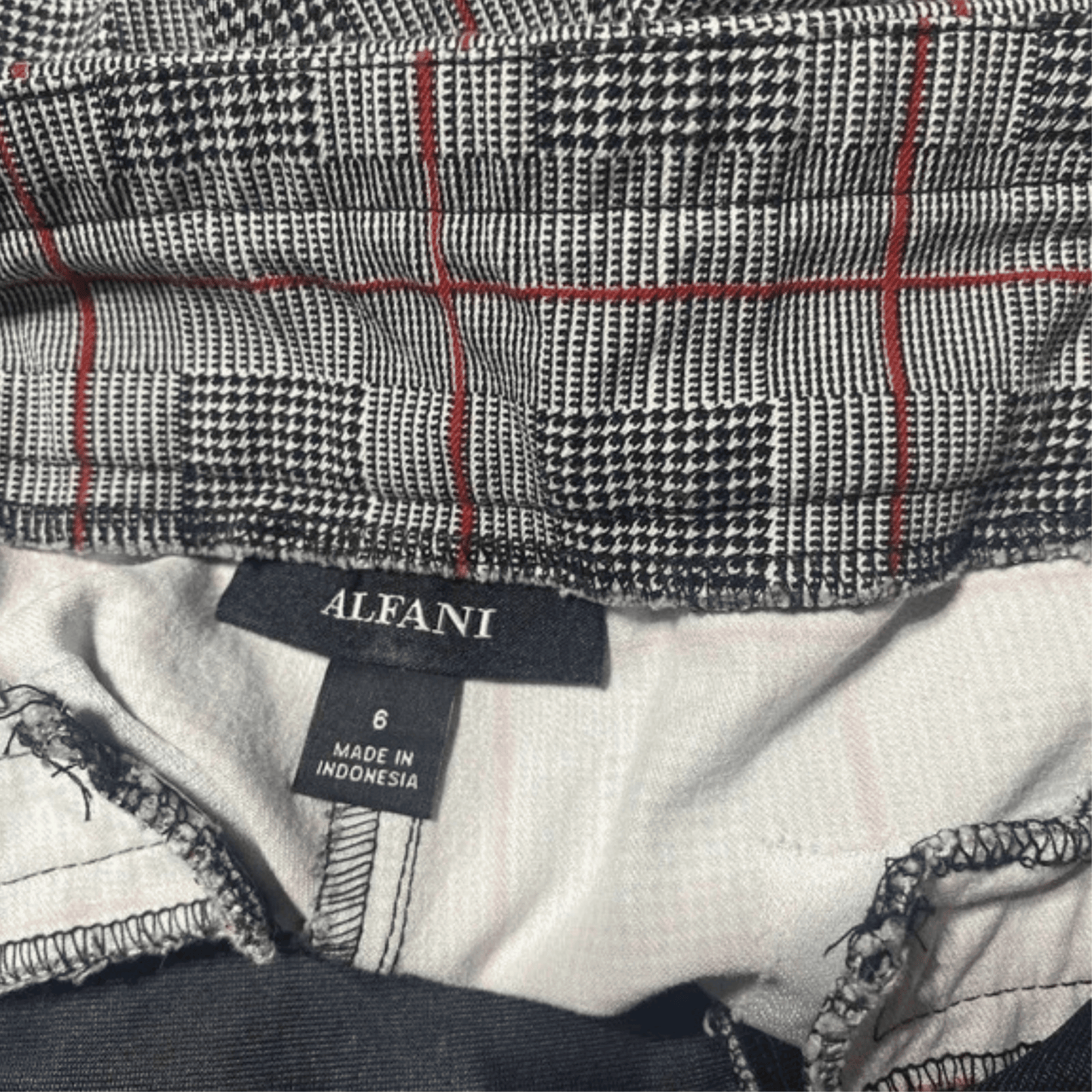 Close-up of a plaid fabric with an Alfani label on a garment.