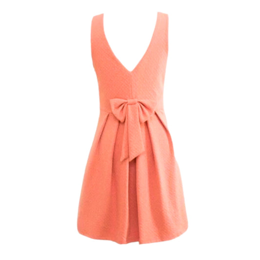 Coral dress with a bow detail on a white background