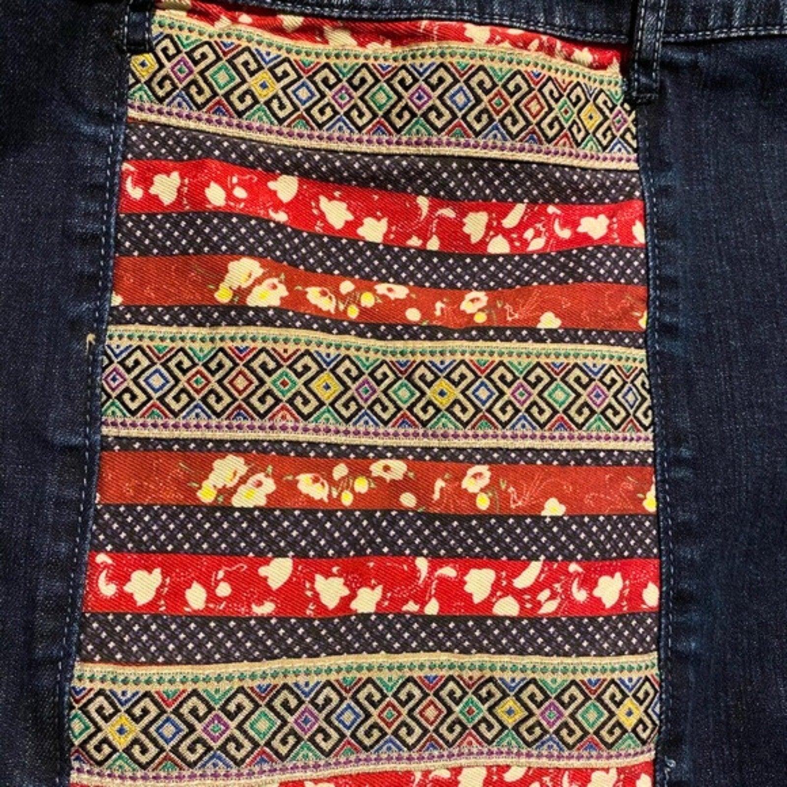Close-up of a colorful patterned pocket on denim fabric