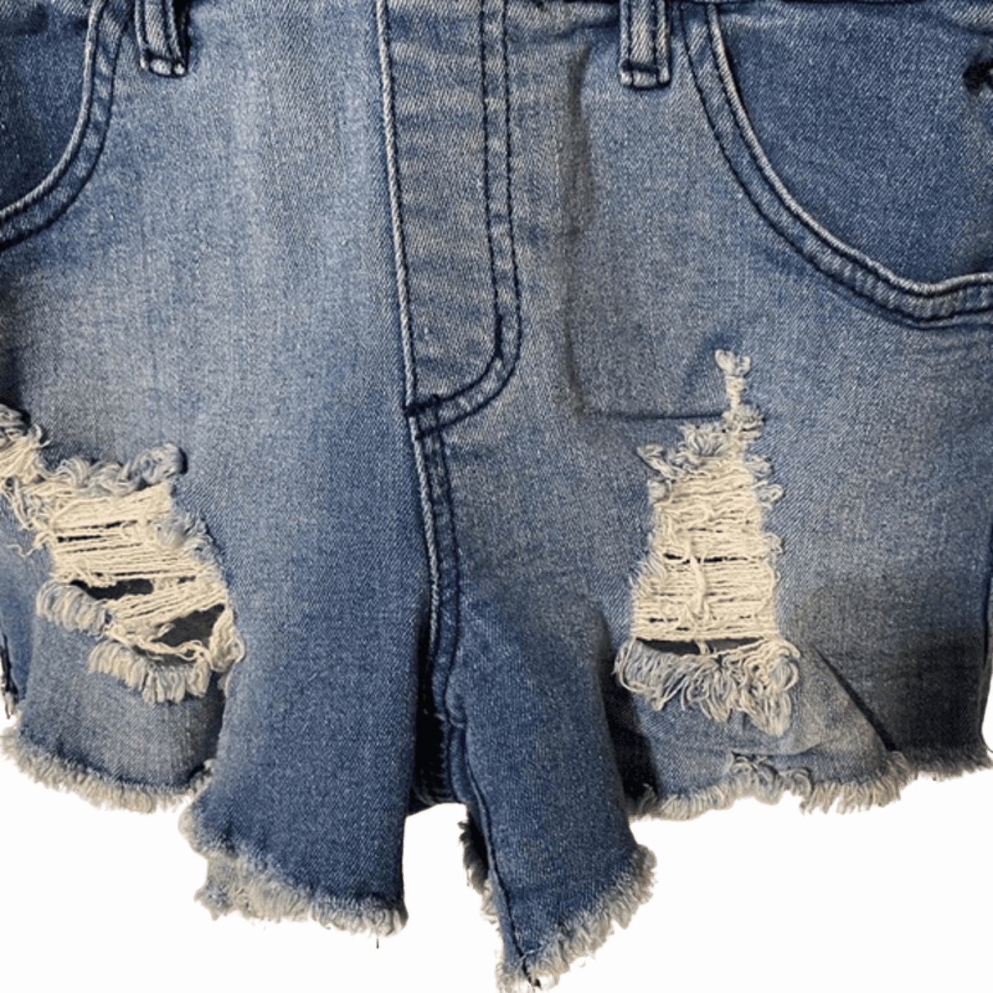 Distressed blue denim shorts on a green background