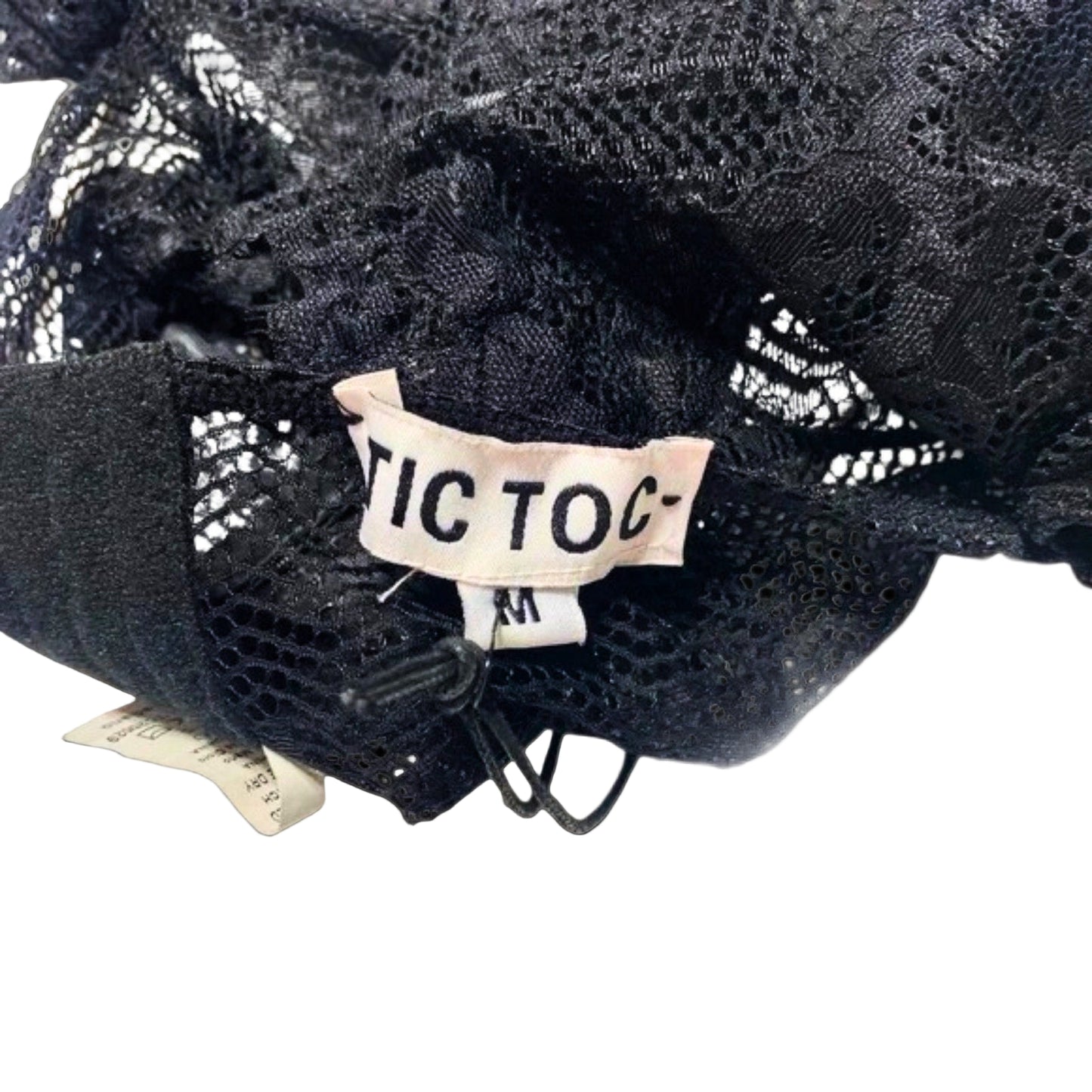 Black lace fabric with a 'TIC TAC' label on a white background