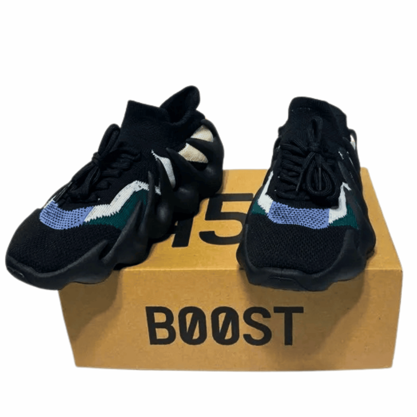 Black sneakers with colorful accents on a cardboard box labeled 'BOOST' against a gray background