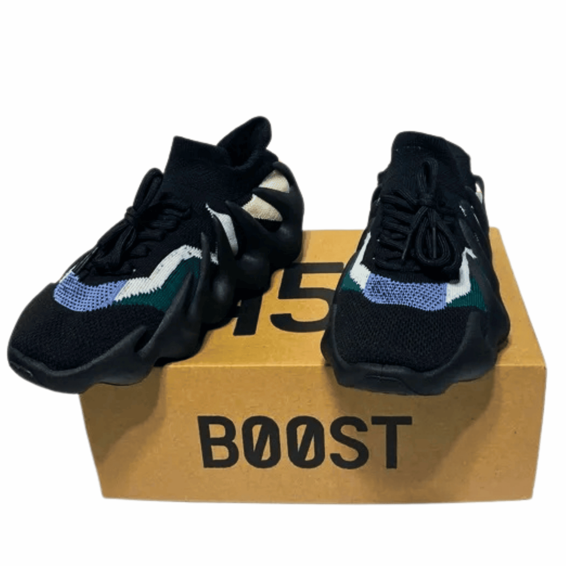 Black sneakers with colorful accents on a cardboard box labeled 'BOOST' against a gray background