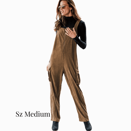 Woman wearing brown overalls on a dark background