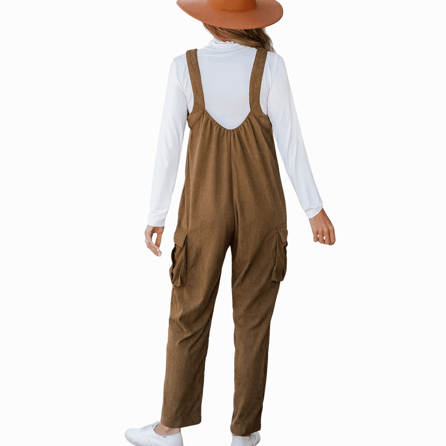 Person wearing brown overalls and a white shirt on a dark gray background