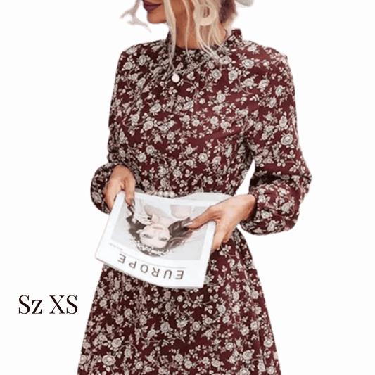 Woman wearing a floral dress holding a magazine against a red background