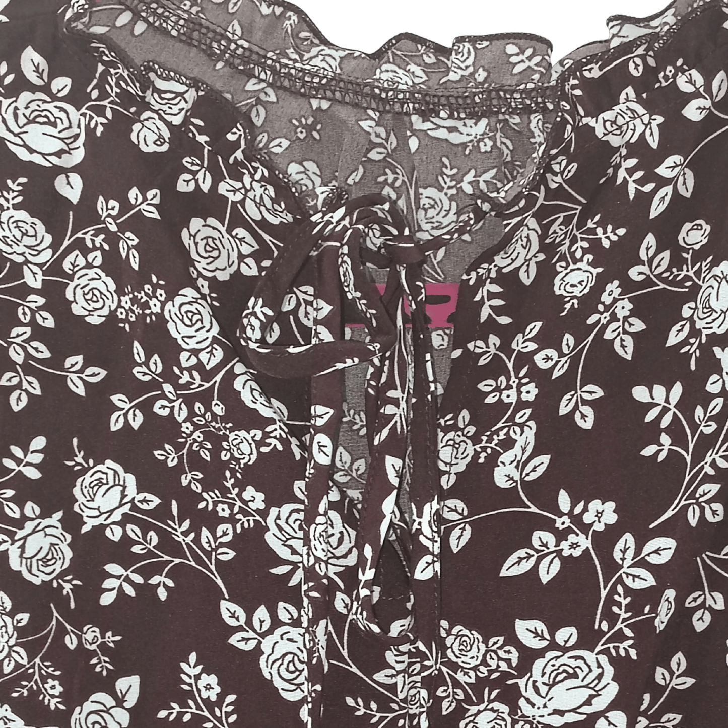 Floral patterned fabric with a focus on black and white roses on a dark background.