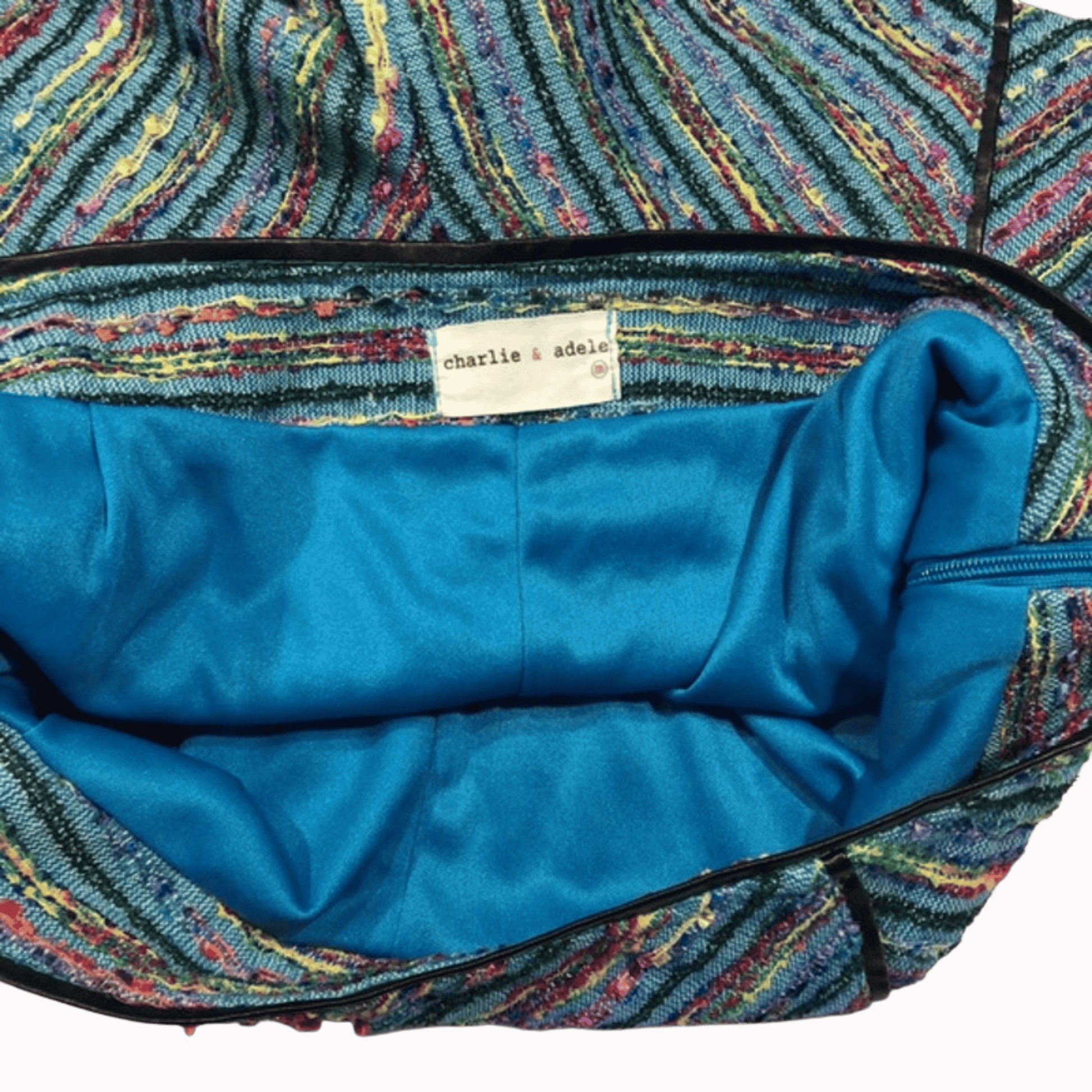 Multicolored fabric interior of a bag with a blue lining and a visible brand label.