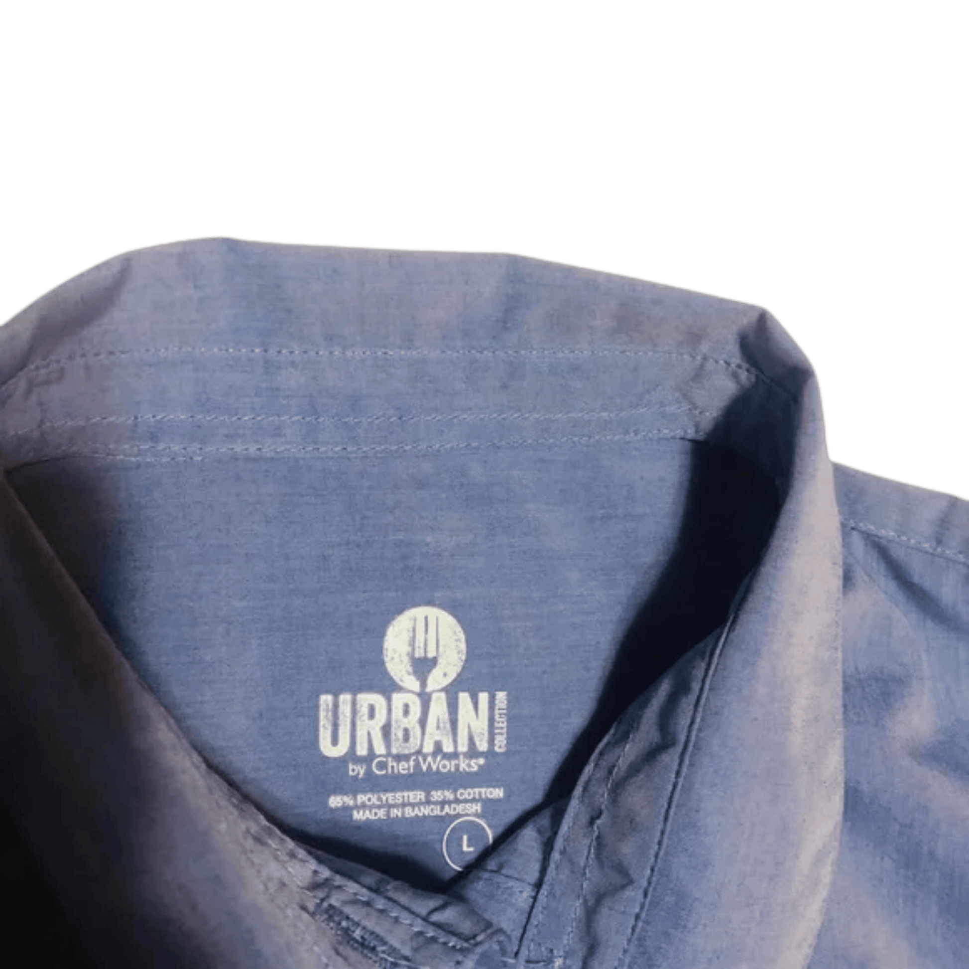 Close-up of a blue shirt with 'Urban by Chef Works' label on a green background