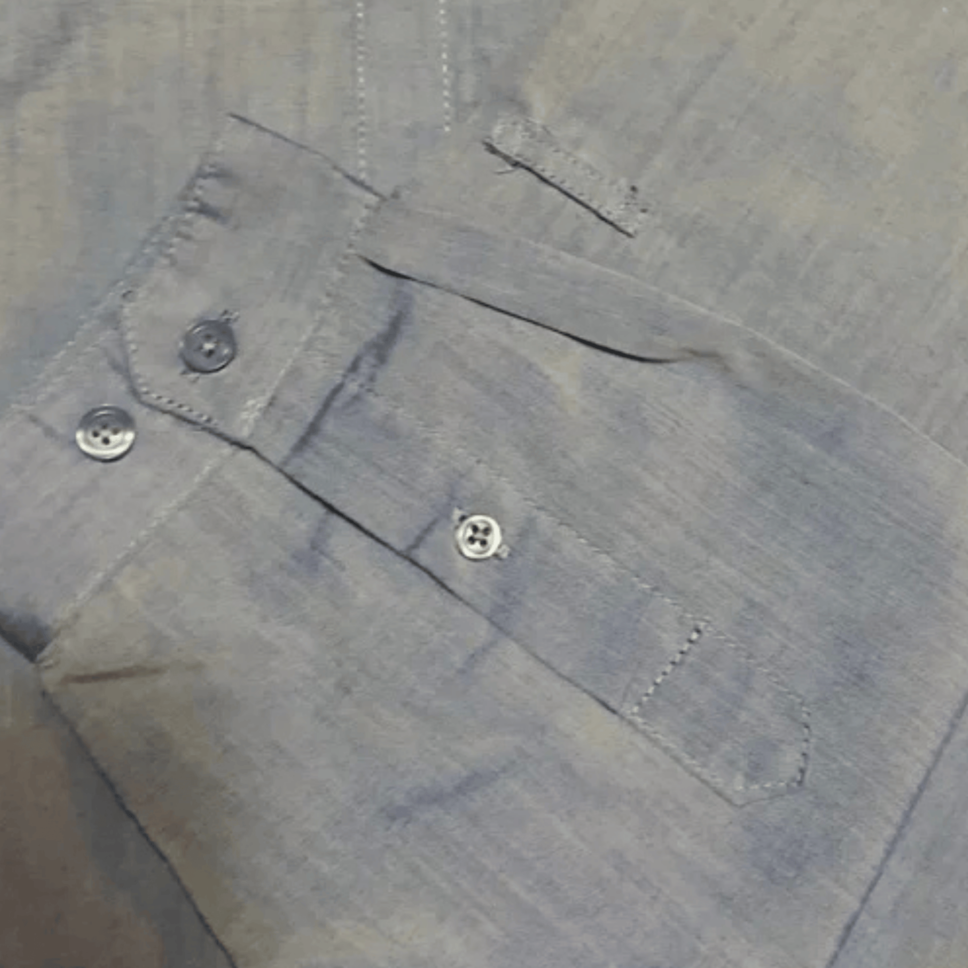 Close-up of a buttoned shirt with a pocket and buttons on a gray background
