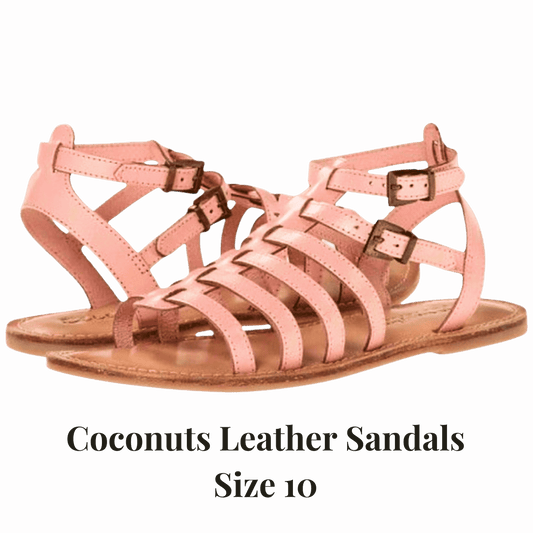 Pink leather sandals with buckles on a red background