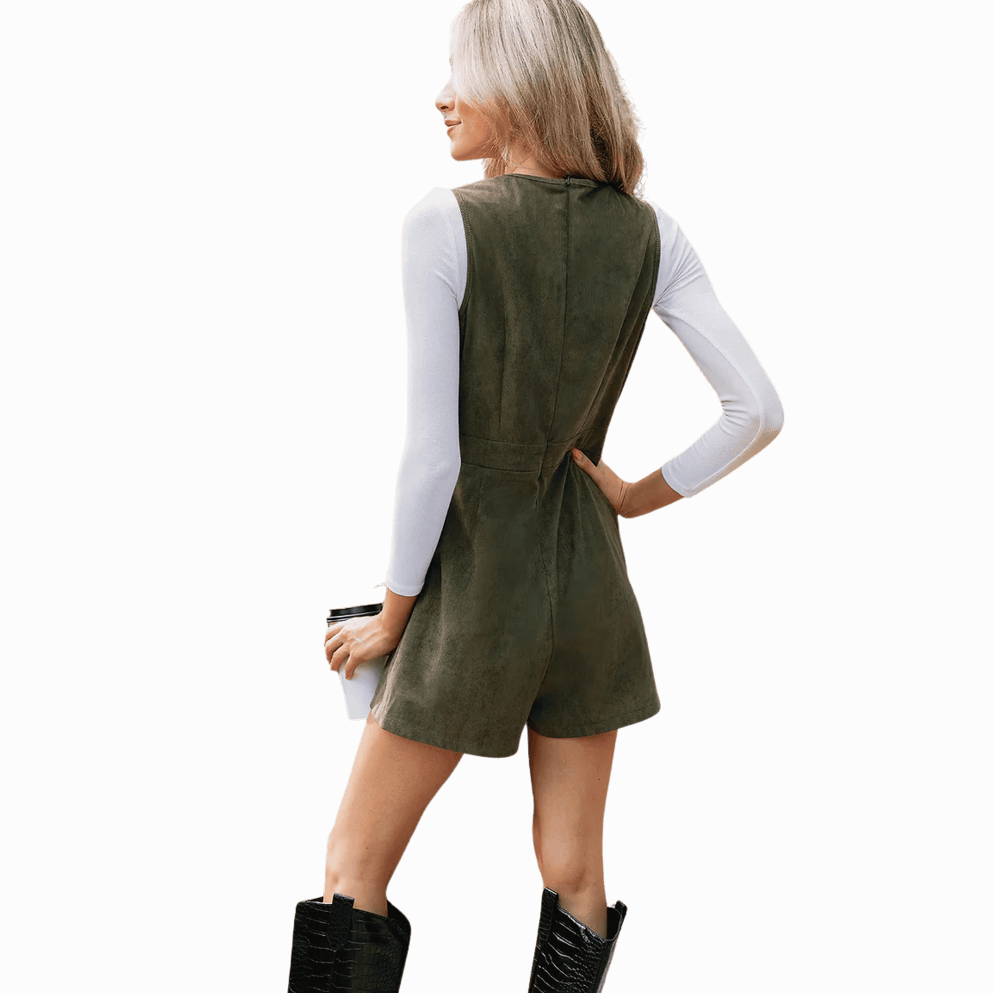 Woman wearing a green dress with a white long-sleeve shirt underneath on a gray background