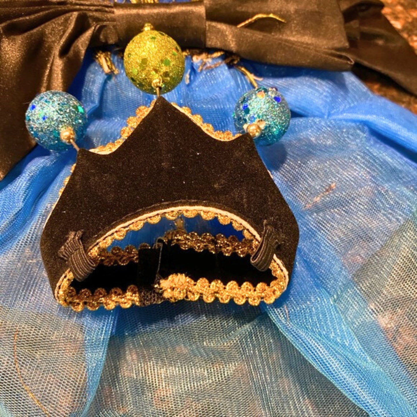 Decorative object resembling a small tent with gold and blue accents on a blue fabric background