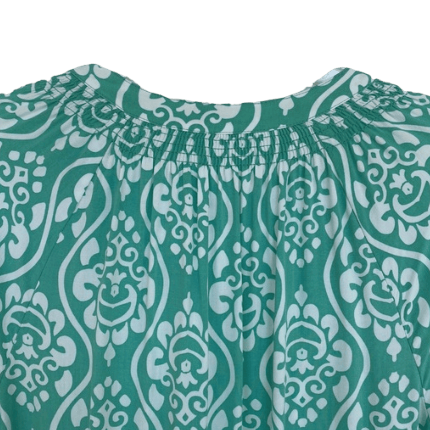 Teal fabric with white intricate pattern on a green background