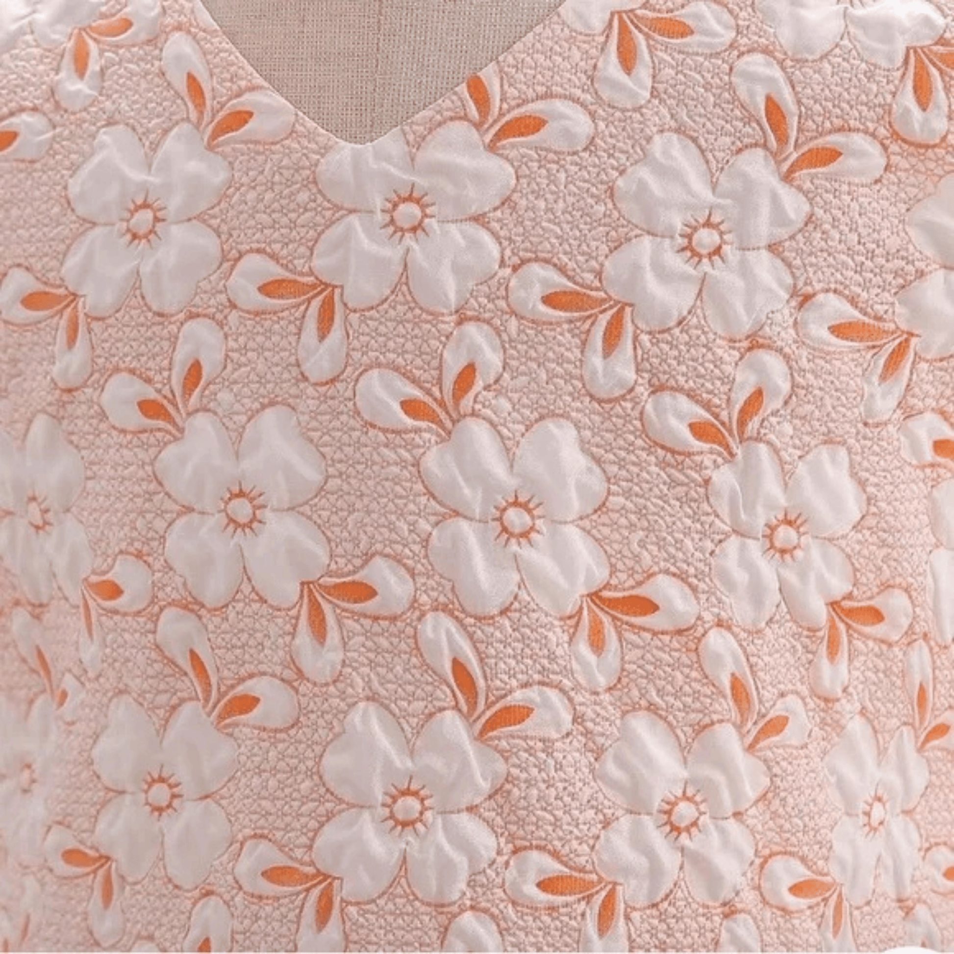Floral patterned fabric with white flowers and orange accents on a pink background