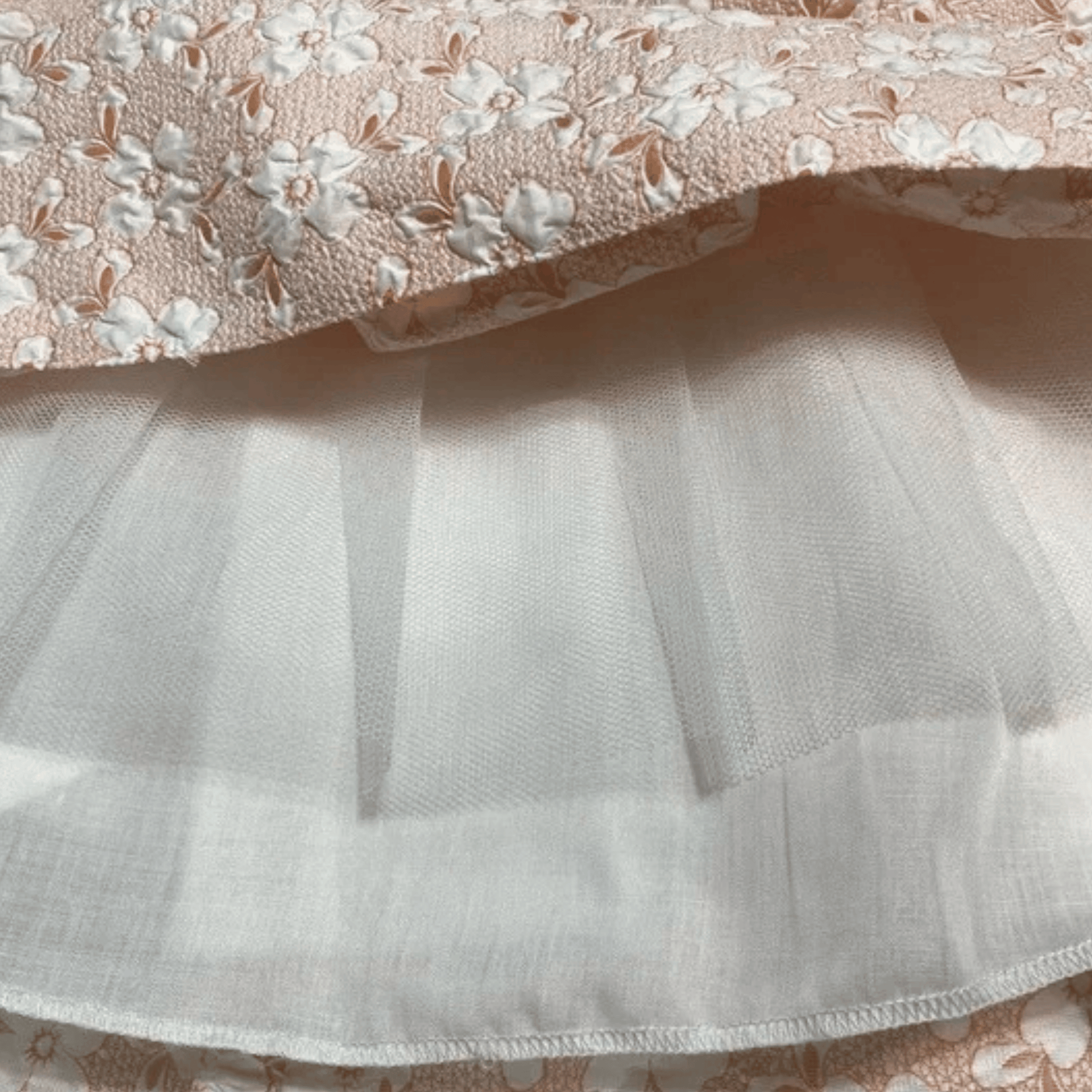 Close-up of floral fabric with a white ruffled layer underneath