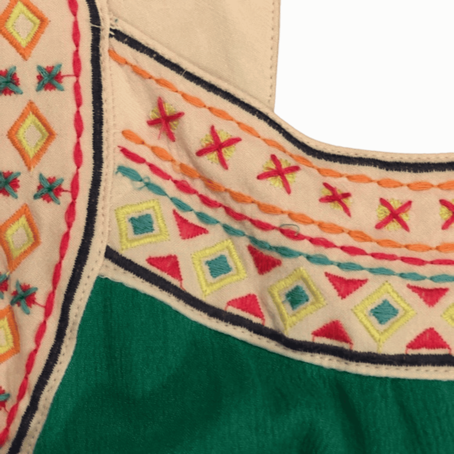 Close-up of embroidered fabric with geometric patterns on a green and beige background