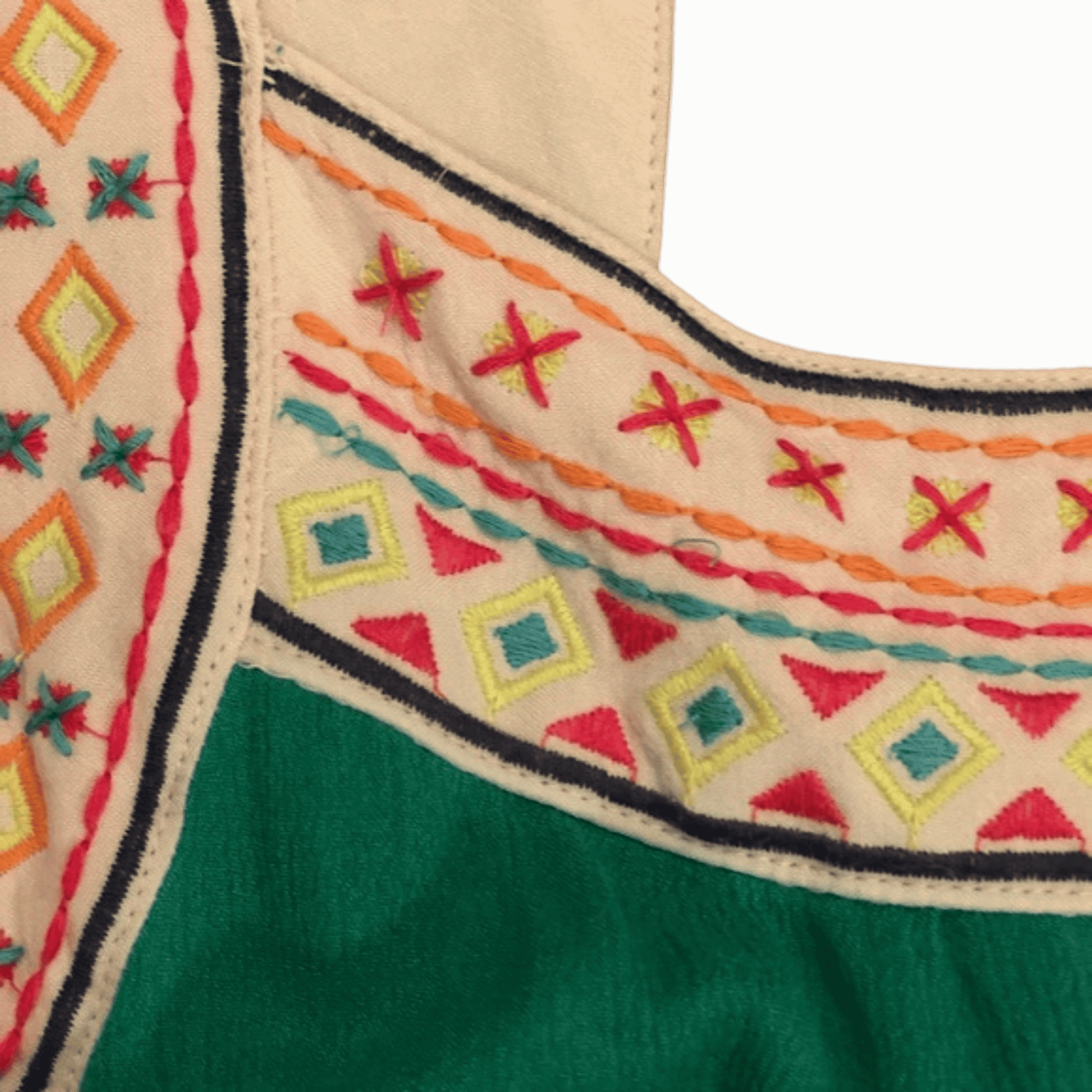 Close-up of embroidered fabric with geometric patterns on a green and beige background