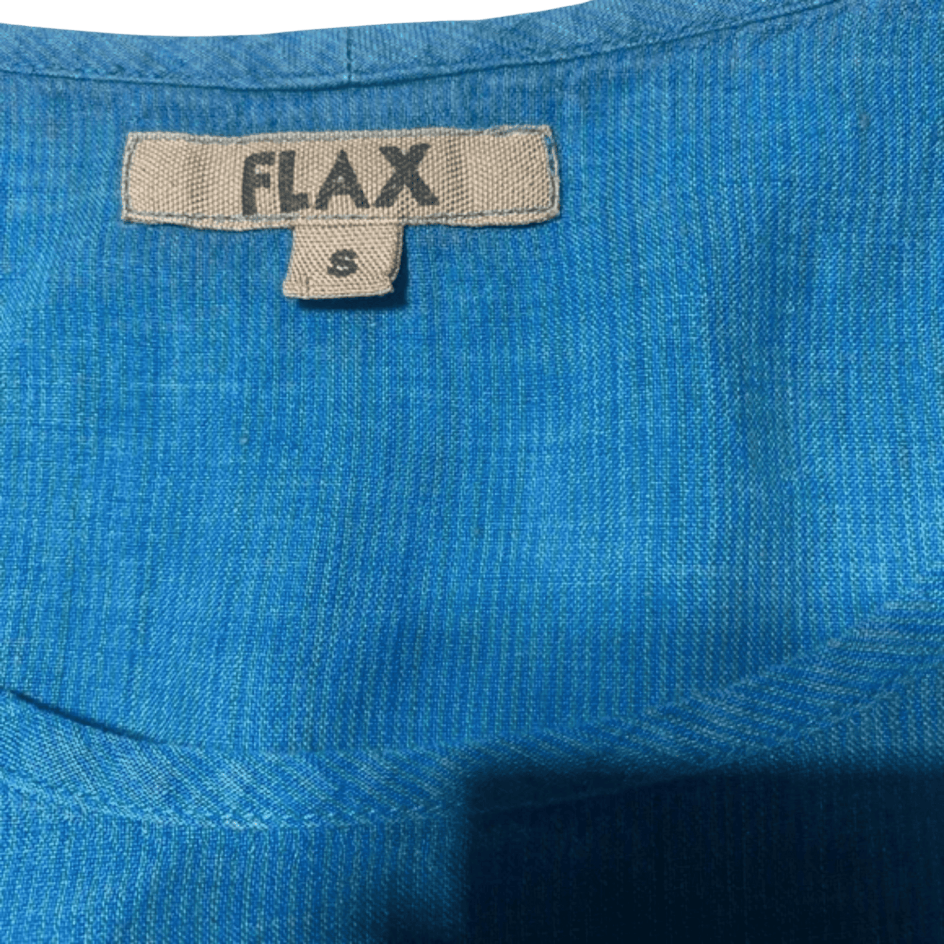 Close-up of blue fabric with a 'FLAX' label on a green background