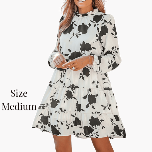 Woman wearing a floral dress with long sleeves on a dark background