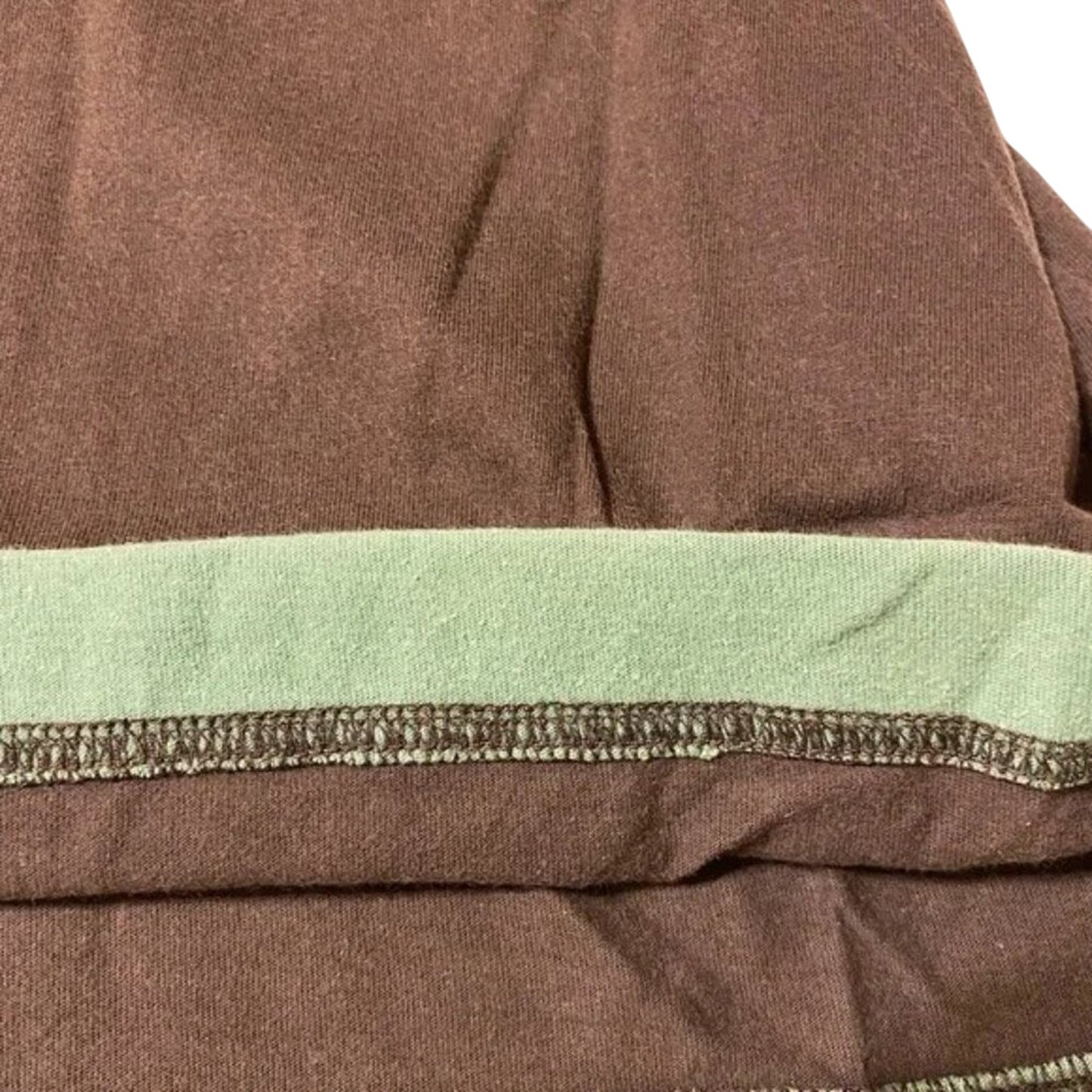 Close-up of a brown fabric with green lining and stitching detail