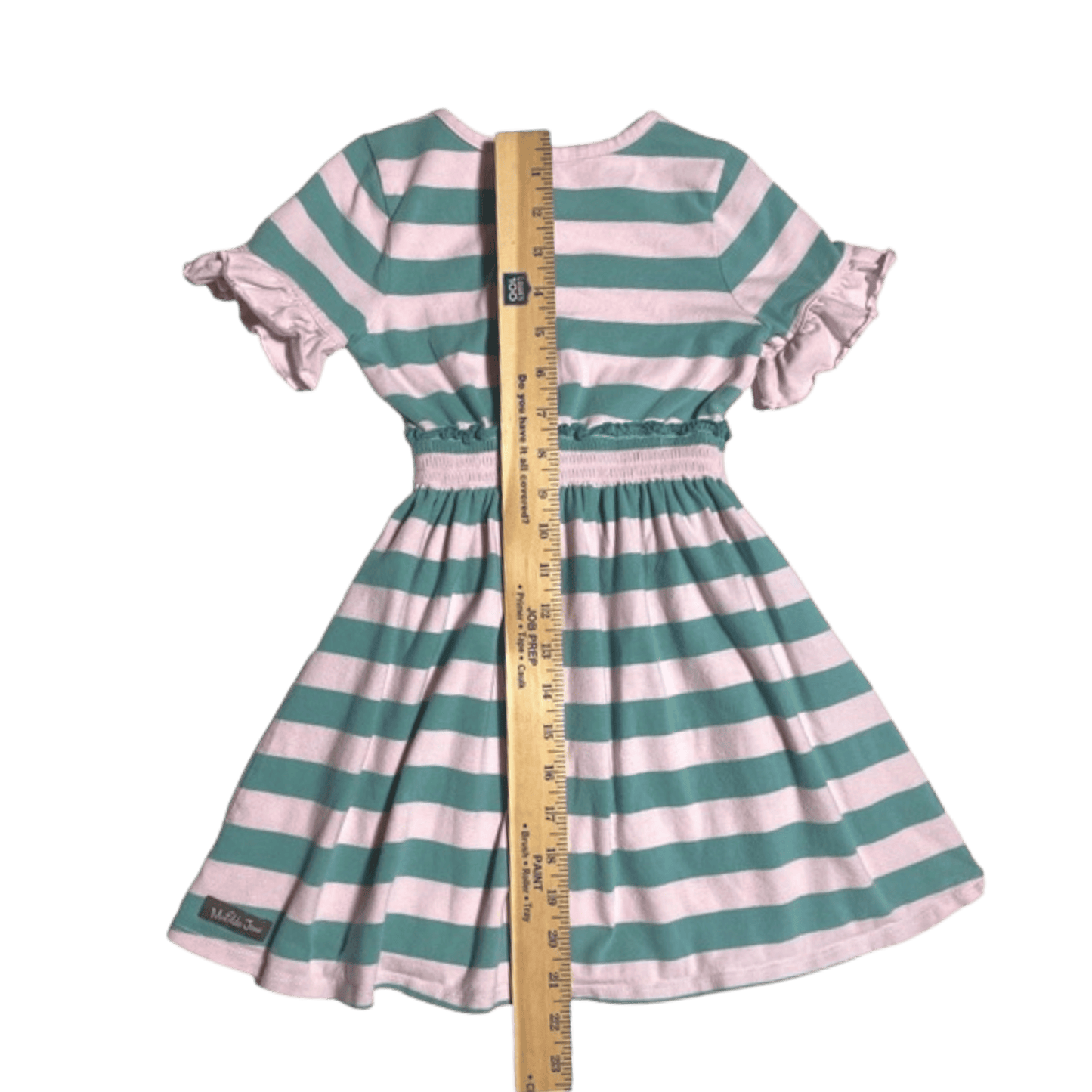 Green and white striped dress with a ruler for size reference on a green background