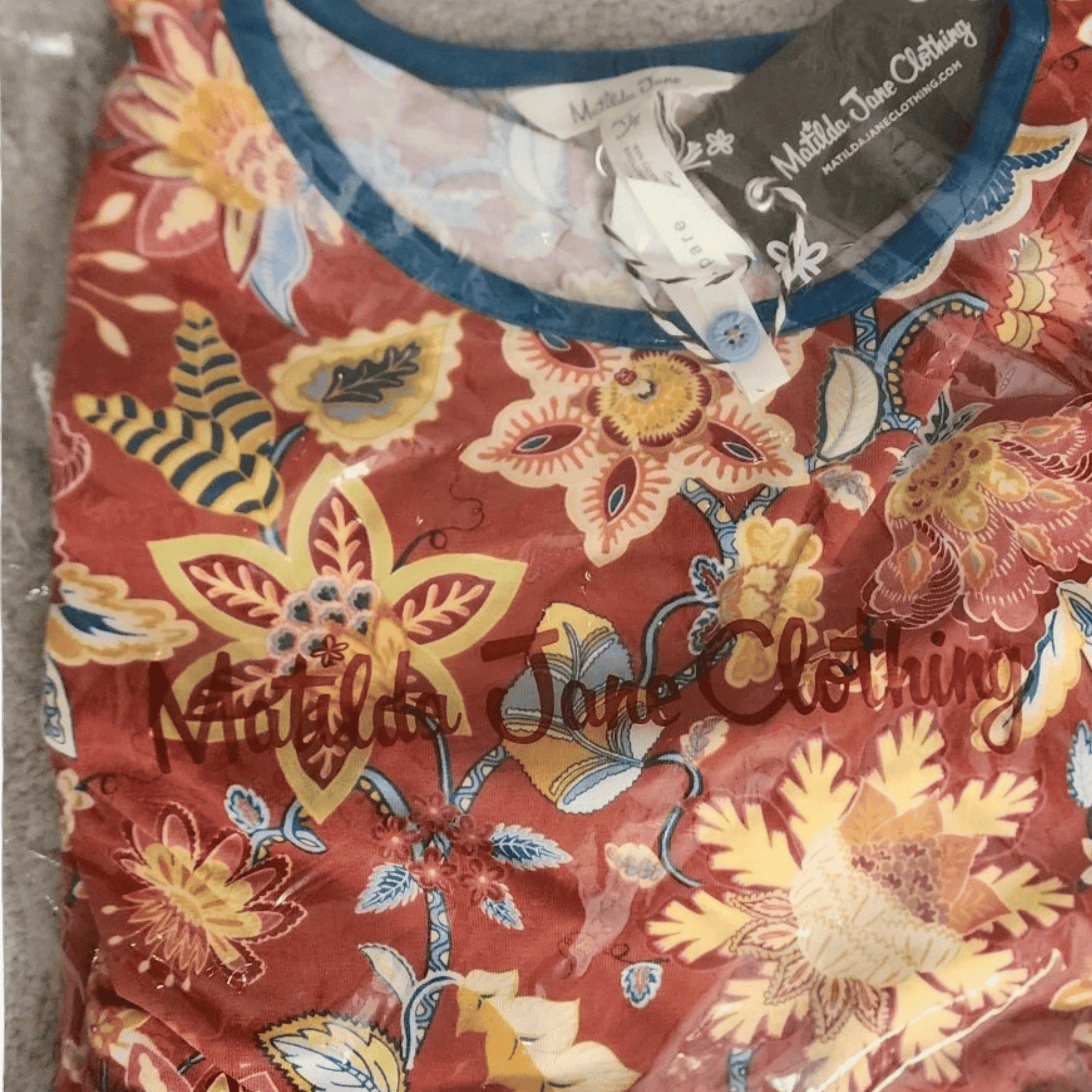 Floral-patterned garment with 'Natalie Jane Clothing' branding on a textured surface.