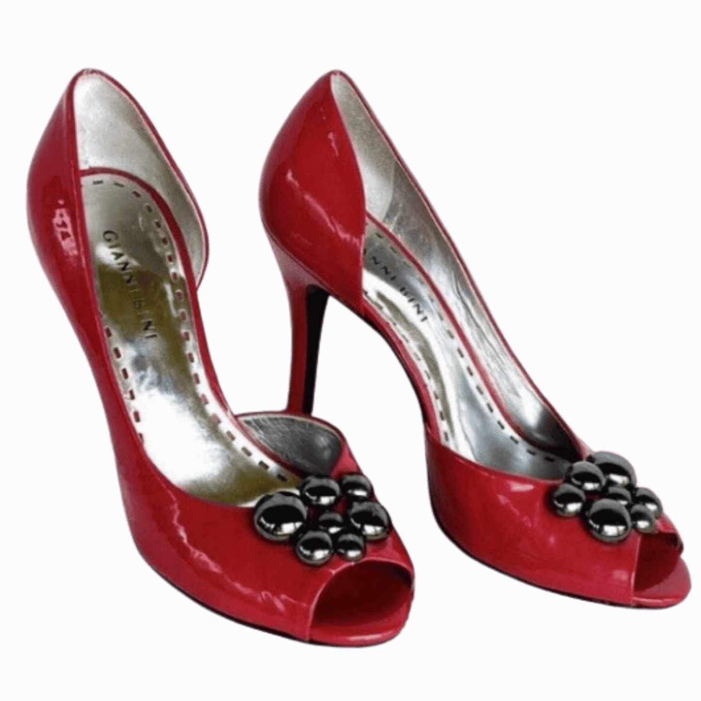 Red high-heeled shoes with decorative elements on a red background