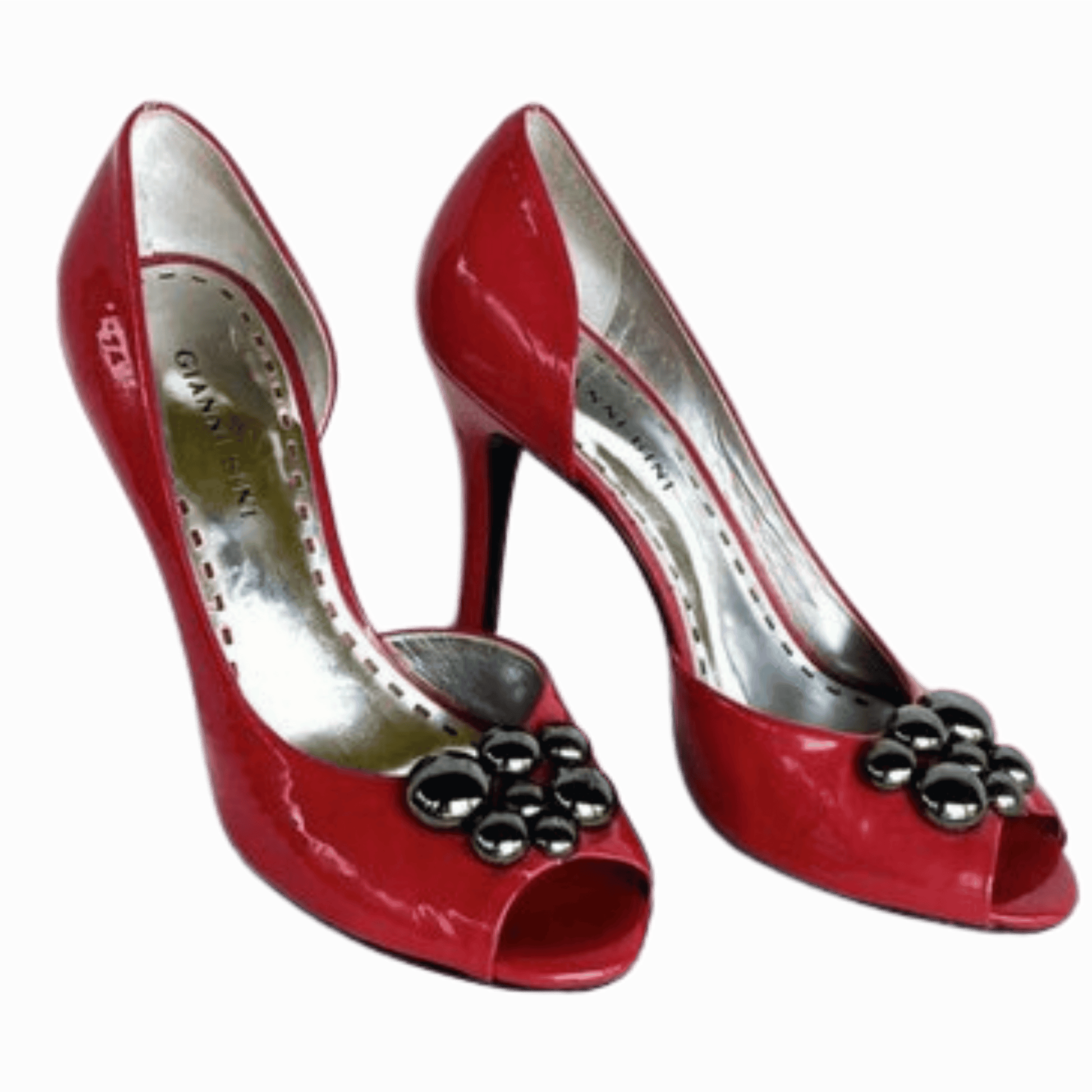 Red high-heeled shoes with decorative elements on a gray background